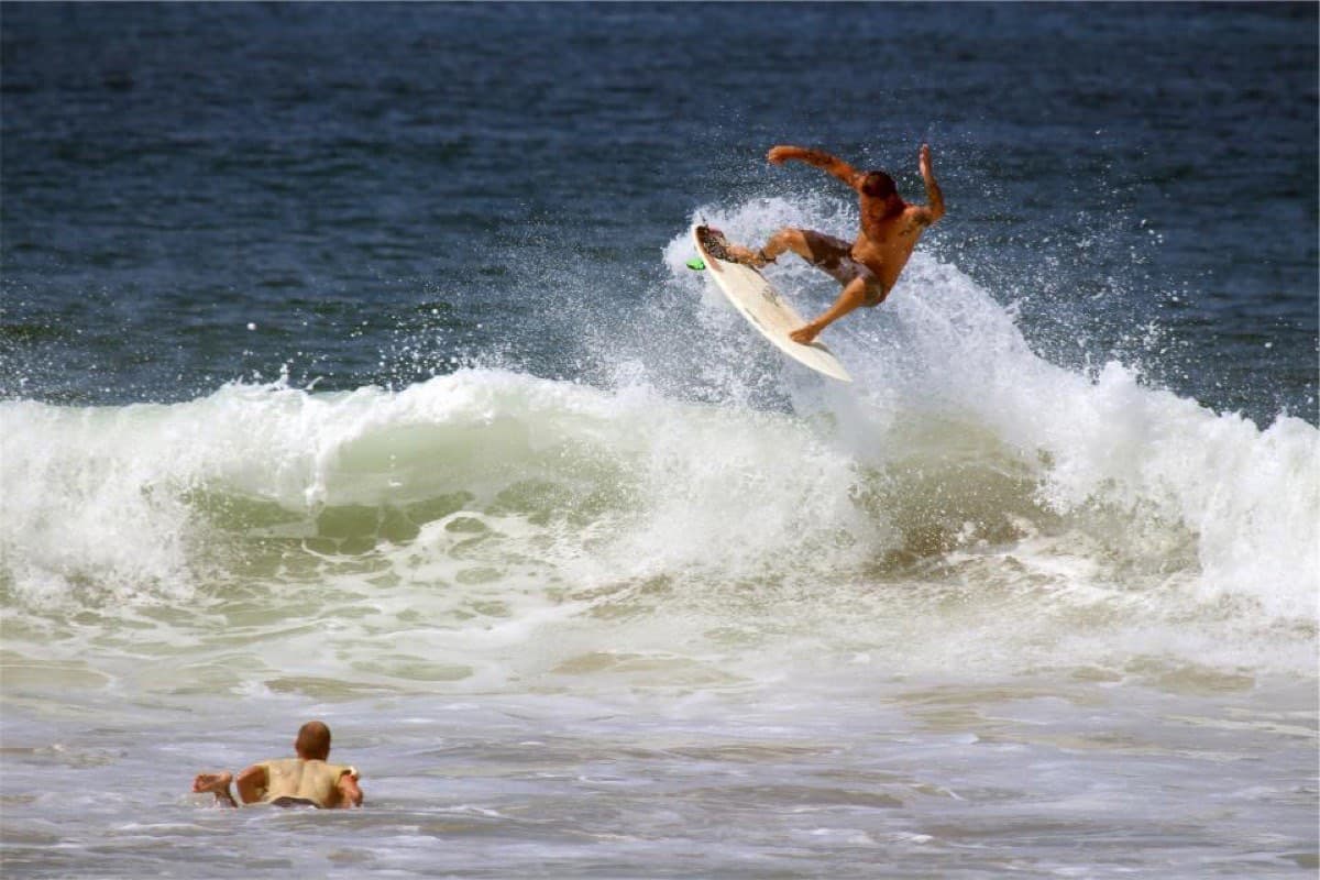 A surfer coming off the lip of a breaking wave, board clear of the water
