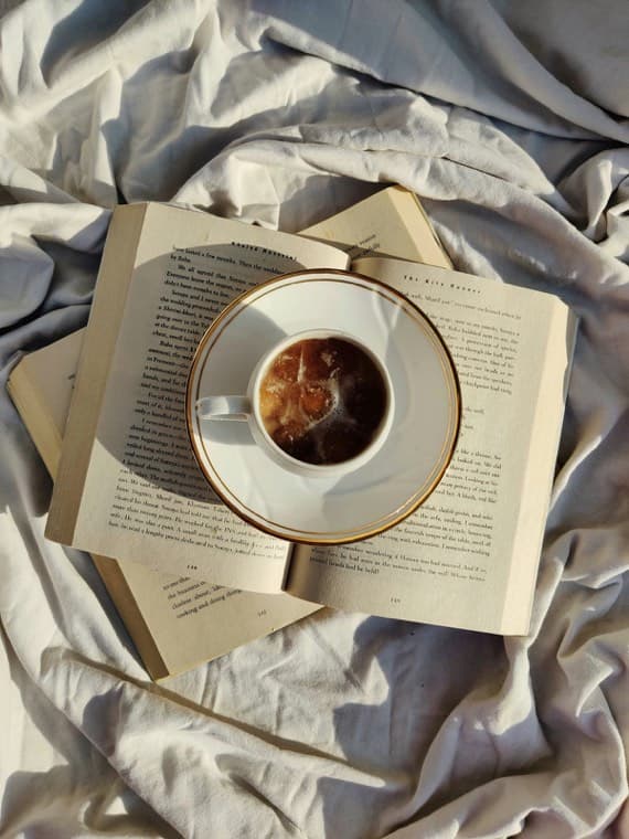 A cup of coffee resting on an open paperback