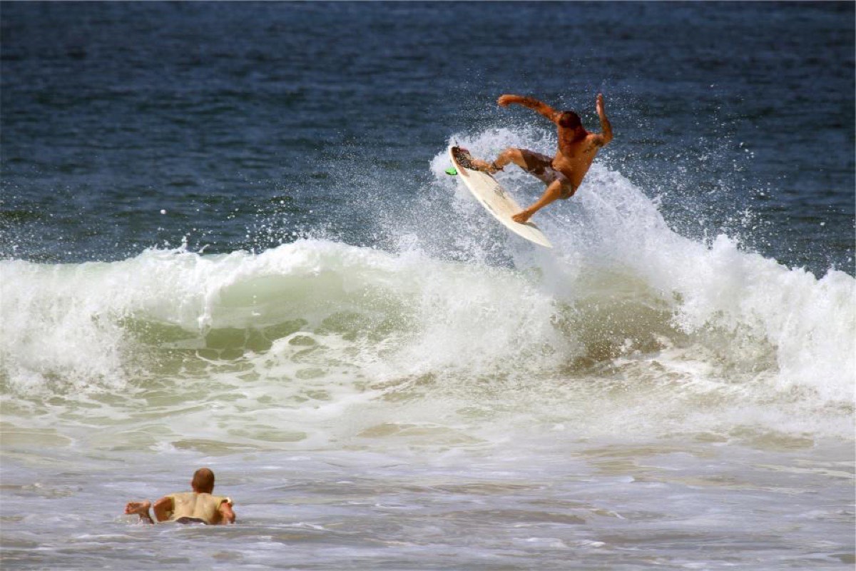 A surfer coming off the lip of a breaking wave, board clear of the water
